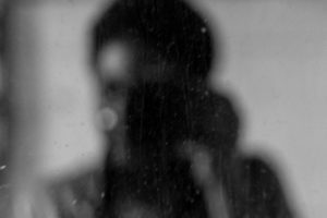 blurred image of a girl holding a camera.