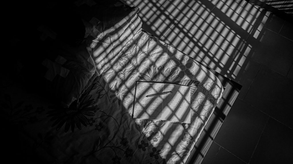 black and white image of bed and book