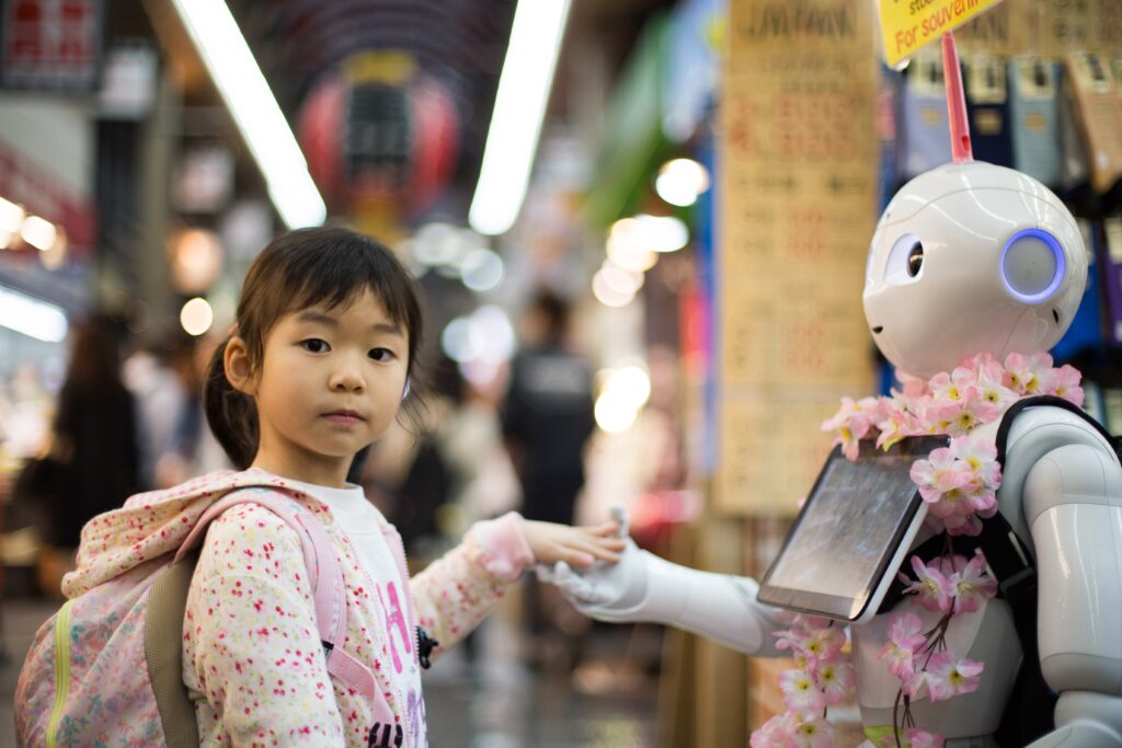 a robot carefully embracing the hand of a little girl